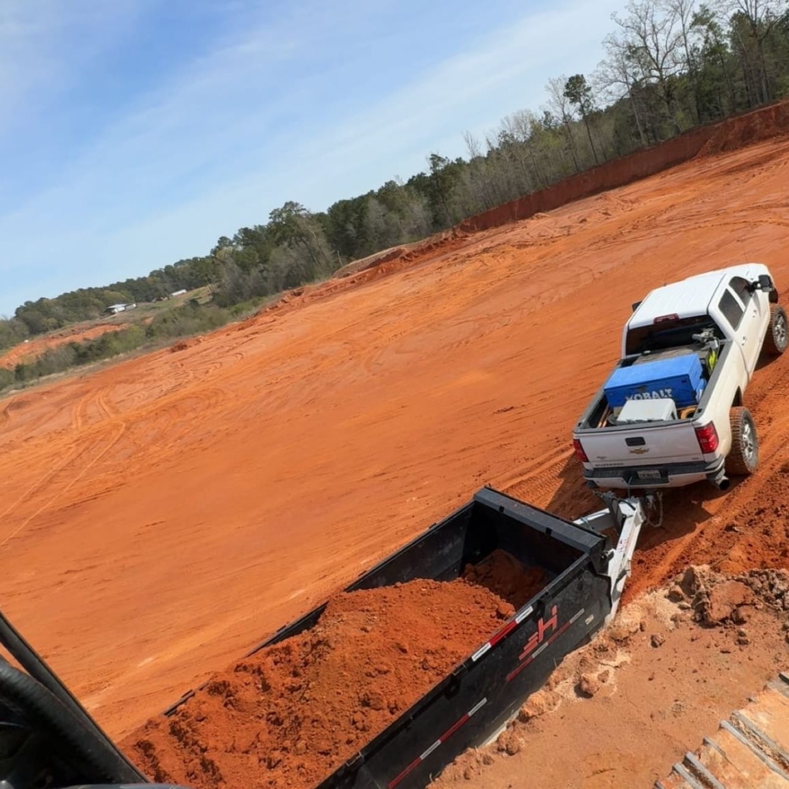 Heavy machinery performing precision land grading and site leveling